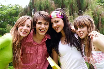 4 teen students huddled around together